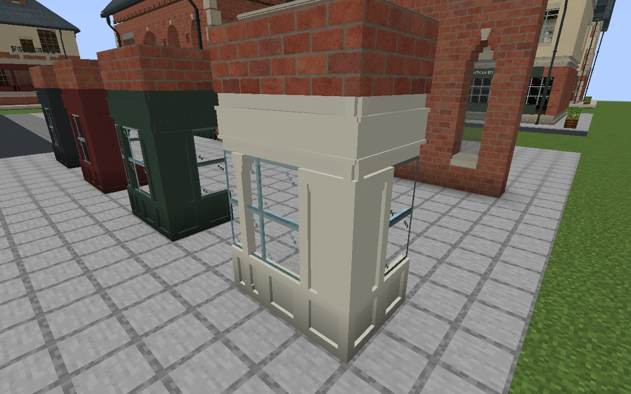 A close view of an ivory corner shopfront with a solid foot, glazed pilasters and a fascia returning beneath the brickwork.